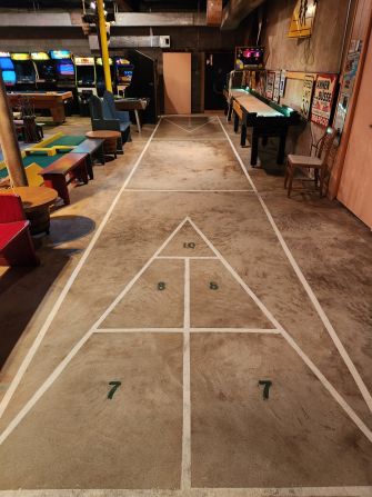 Ahlgrim Acres is the centerpiece of "the community room," which includes a full-sized shuffleboard court (pictured), a ping pong table, and a range of video games.