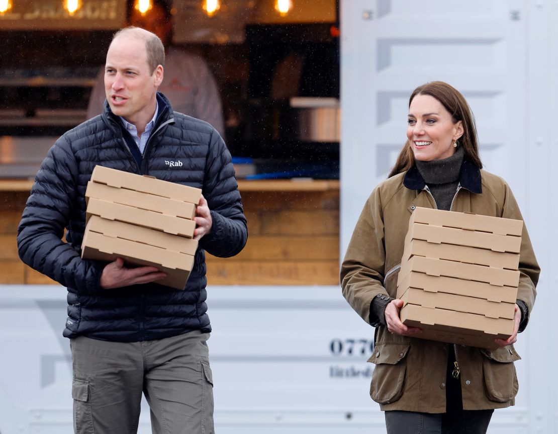 William and Kate carry takeout pizza boxes as they visit Dowlais Rugby Club in Merthyr Tydfil, Wales on April 27.  