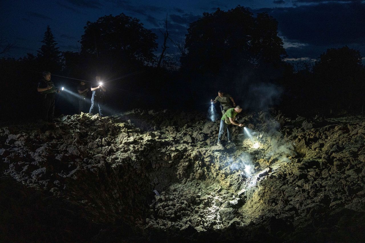 Ukrainian police officers look inside a crater for fragments of a rocket after a <a href="https://www.cnn.com/europe/live-news/russia-ukraine-war-news-2-15-23/h_36b18a3c96a1d3f3a7e6bf98ede3d37c" target="_blank">Russian attack</a> on a residential neighborhood in Pokrovsk, Ukraine, on Wednesday, June 21.