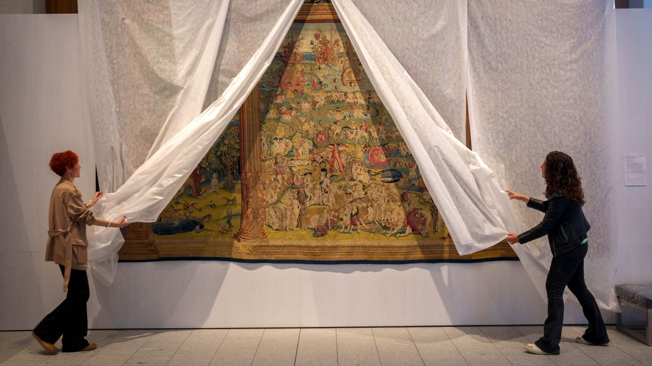 Staff members of the museum unveil a tapestry called "El jardin de las delicias" at the Royal Collections Gallery in Madrid, Spain, Friday, May. 19, 2023. Spain is set to unveil what is touted as one of Europe's cultural highlights of the year with the opening in Madrid of The Royal Collections Gallery next month. The Gallery will feature master paintings, tapestries, sculptures, decorative art pieces, armory and sumptuous royal furniture collected by Spanish monarchs over five centuries that spanned the Spanish Empire of the Hapsburg and Bourbon dynasties.