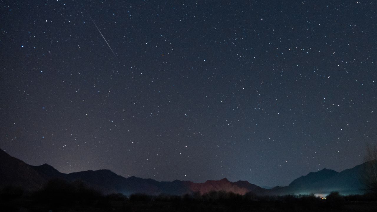 A meteor of Geminid meteor shower streaks across the night sky over the Lhasa River on December 14, 2022 in Lhasa, Tibet Autonomous Region of China.