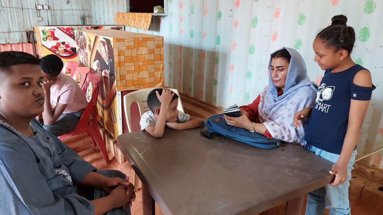 Sabah Ahmed (center right) sits in a cafe with her sons Mohamed, Zeyazen and Kareem and daughter, Renad, while they wait to be interviewed at the US embassy in Khartoum on March 9, 2023.