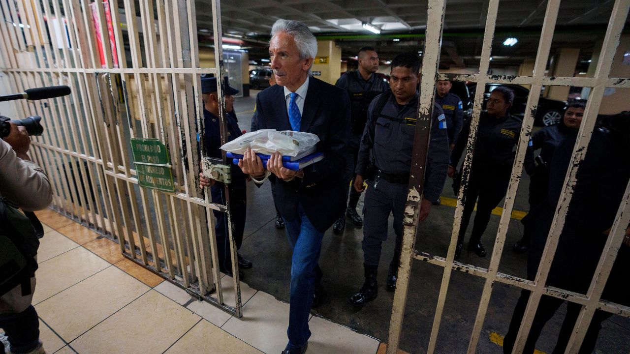 Prominent Guatemalan journalist José Rubén Zamora is escorted by police in handcuffs to court for a hearing related to his trial on May 30, 2023.