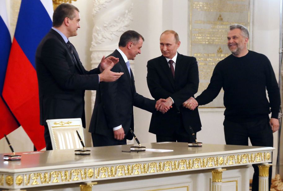 Putin shakes hands with Speaker of Crimean legislature Vladimir Konstantinov, second from left, and Sevastopol mayor Alexei Chalyi as Crimean Premier Sergei Aksyonov looks on in March 2014. Putin had just signed a treaty to incorporate Crimea into Russia.