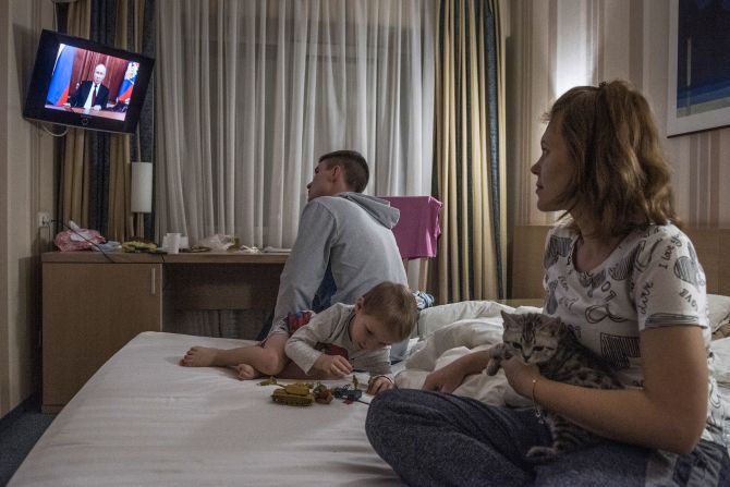A family that left eastern Ukraine watches Putin's televised address from a hotel room in Taganrog, Russia, in February 2022. In lengthy remarks, Putin blasted Kyiv's growing security ties with the West and appeared to cast doubt on Ukraine's right to self-determination. He would soon order troops into separatist-held parts of eastern Ukraine.