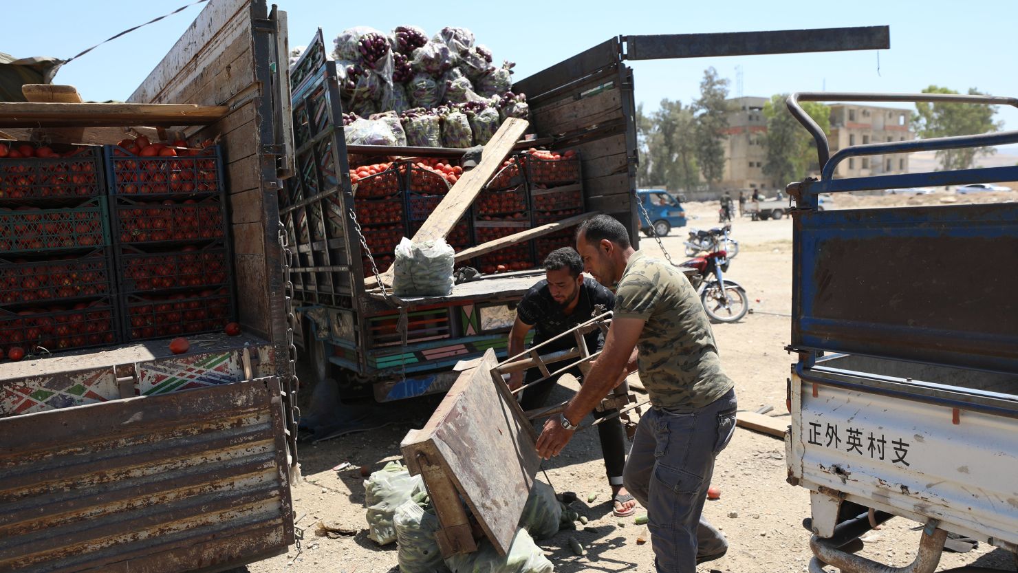 People inspect a damaged truck at the fruit and vegetable market following a reported airstrike in Idlib, Syria, June 25, 2023. 