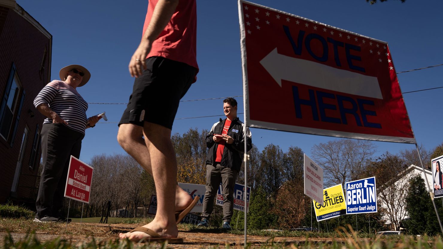 A voter walks past people handing out election literature on November 8, 2022 in Clemmons, North Carolina. 