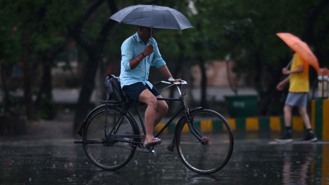 Commuters out in the light rain on the Sector 21 road, on June 25, 2023 in Noida, India.