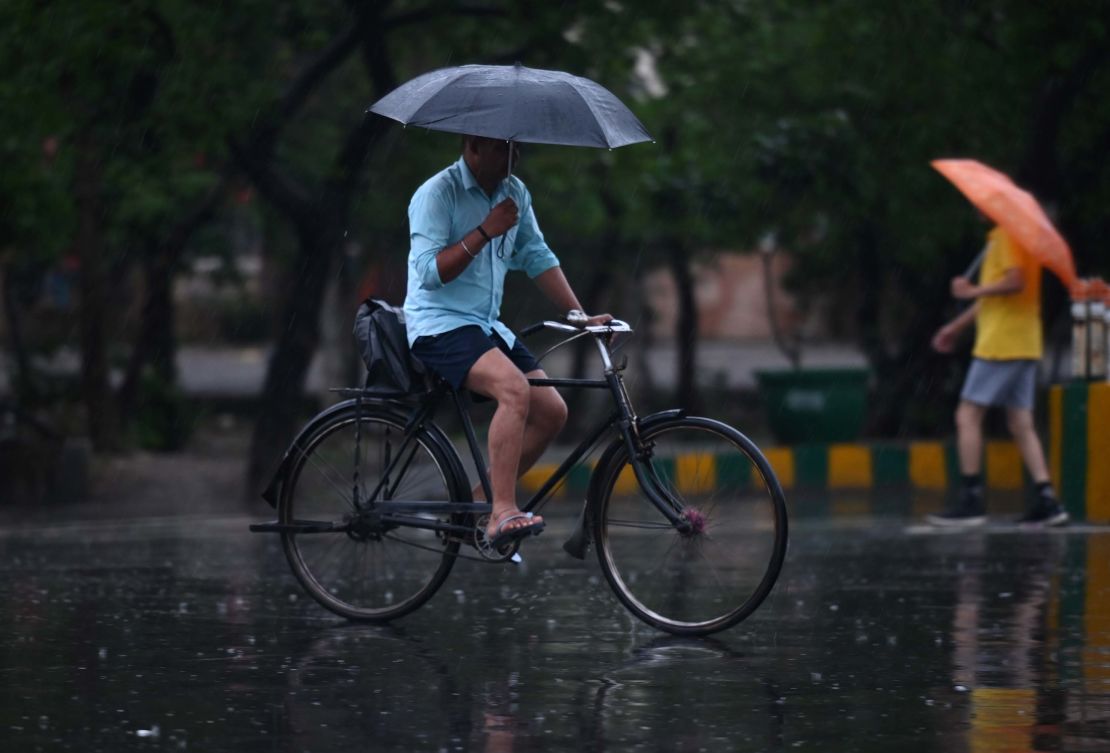 Commuters out in the light rain on the Sector 21 road, on June 25, 2023 in Noida, India.
