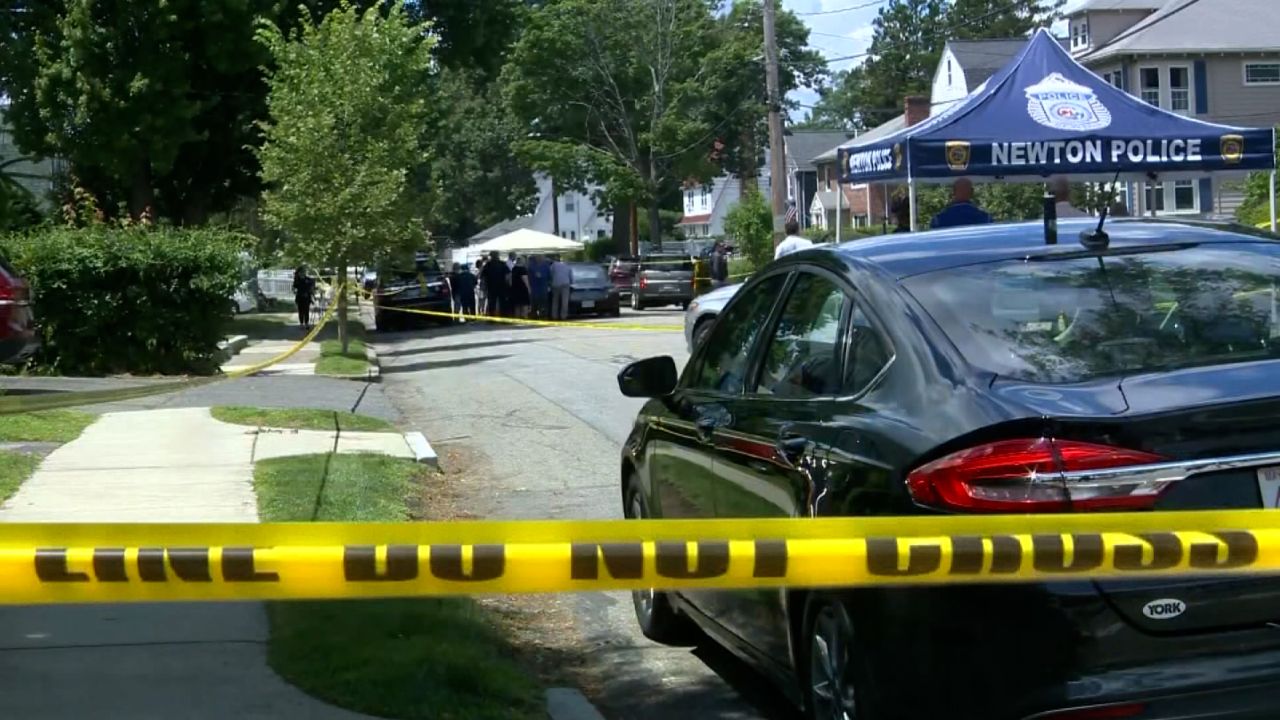 Police are seen at the location of an apparent triple homicide in Newton, Massachusetts, on Sunday.