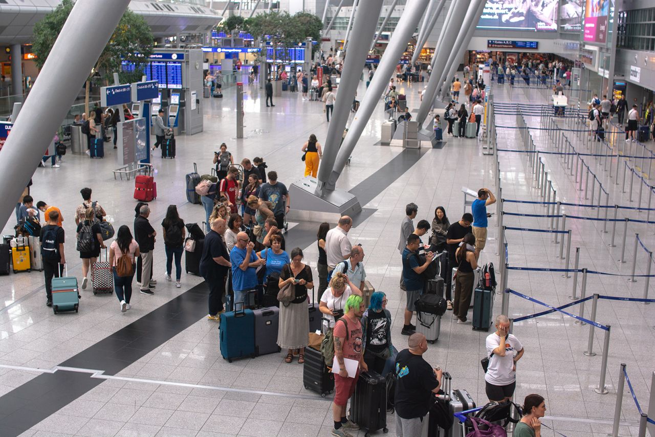 The flight attendants always travel with carry-on luggage only and generally speaking encourage others to do the same. Pictured here: travelers waiting to check in luggage at Duesseldorf airport in Duesseldorf, Germany in June 2023.