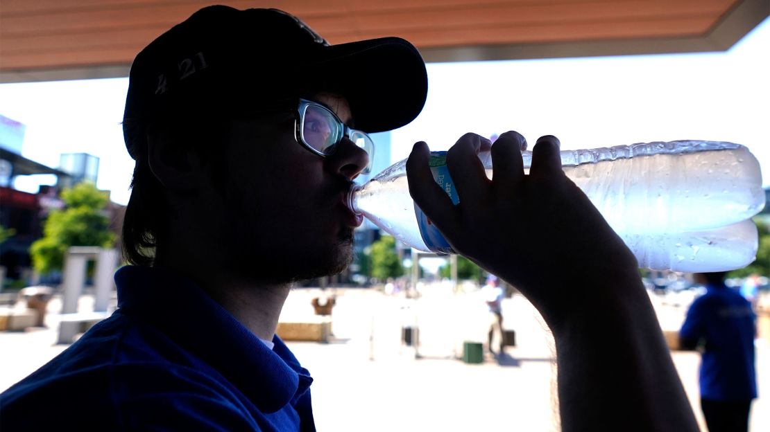 Texas resident drinks water while working security outside in Arlington, Texas, on Monday.