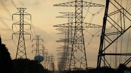 The sun rises over power lines Tuesday, June 27, 2023, in Houston. Meteorologists say scorching temperatures brought on by a heat dome have taxed the Texas power grid and threaten to bring record highs to the state. 