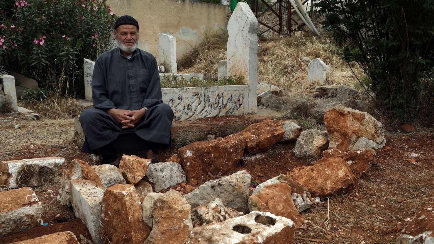 Mohammed Hassan Masto sits next to the grave of his brother Lutfi, who was killed on Wednesday, May 3, in a US military strike, in the village of Qorqanya, a rural area in northern Idlib province, Syria, Sunday, May 7, 2023.