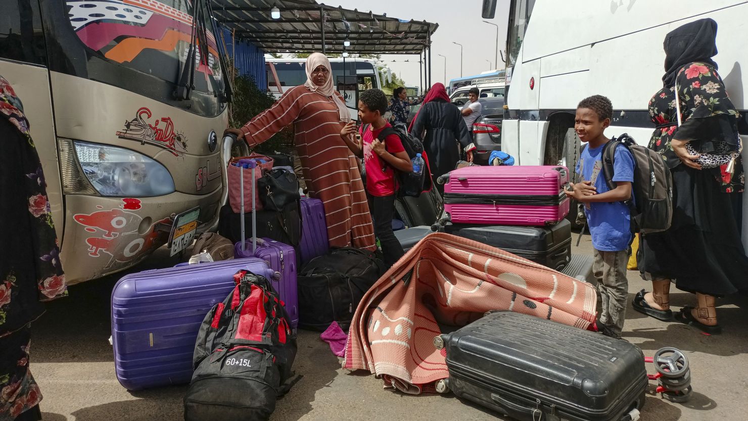 Passengers fleeing war-torn Sudan disembark at the Wadi Karkar bus station near the Egyptian city of Aswan, on April 25, 2023. 