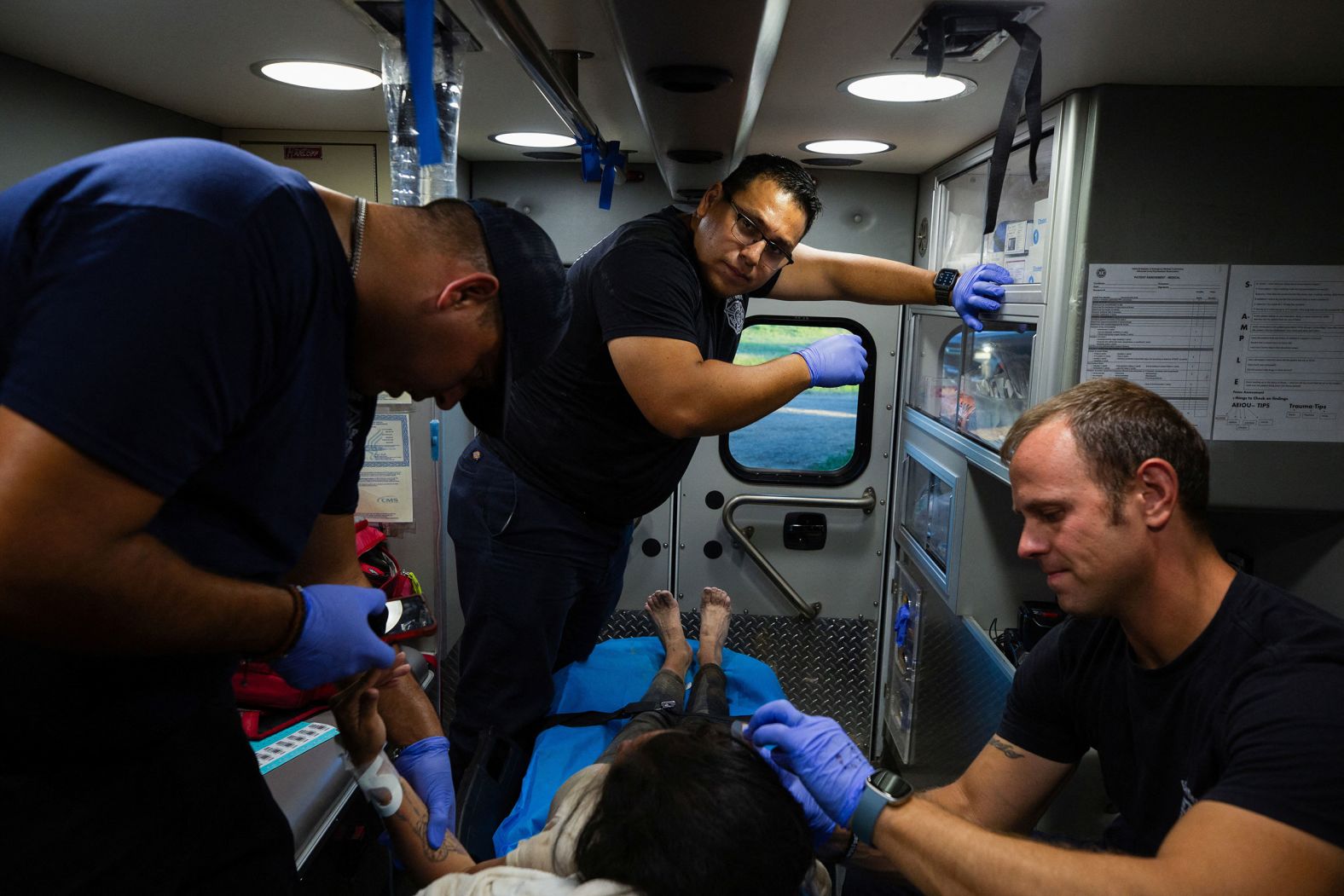 EMTs treat a woman who was suffering from heat exhaustion in Eagle Pass. She recovered with their help, according to the Reuters news agency.