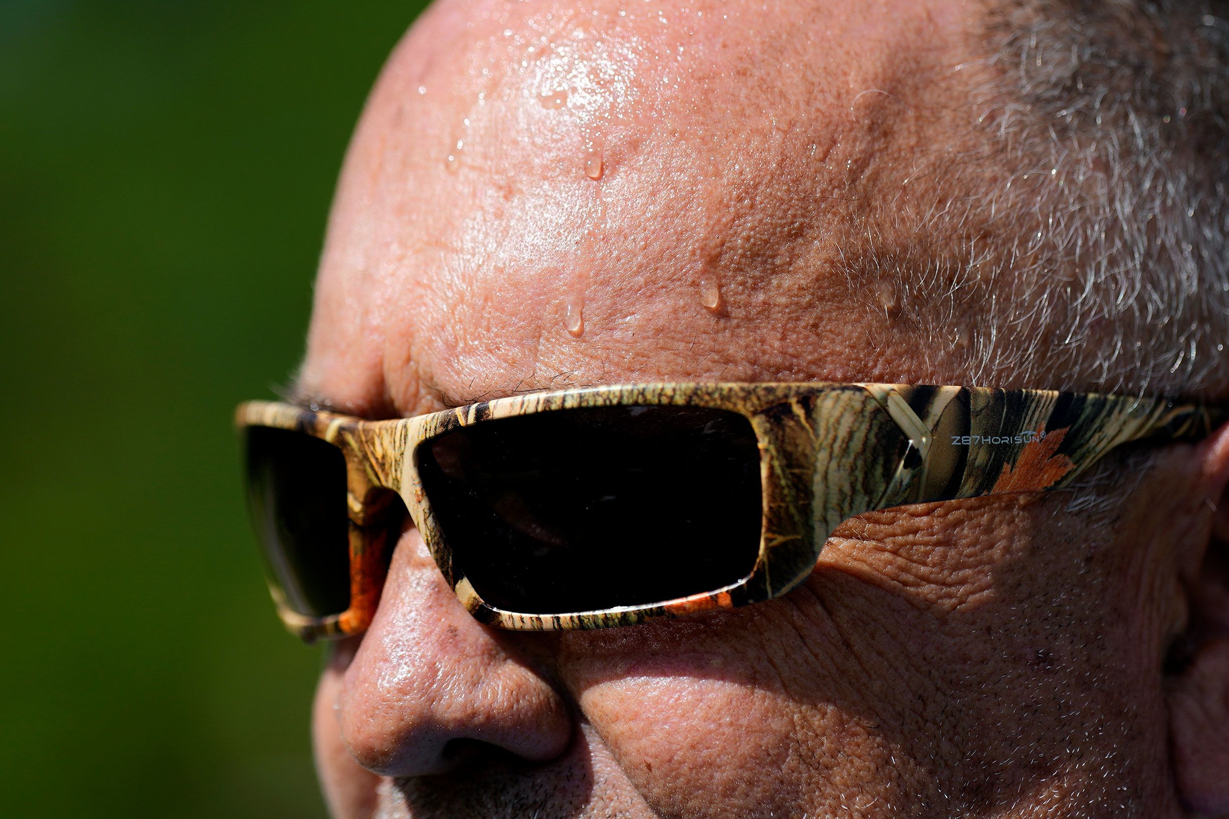 Sweat runs down the face of Robert Harris as he digs fence-post holes in Houston on June 27.