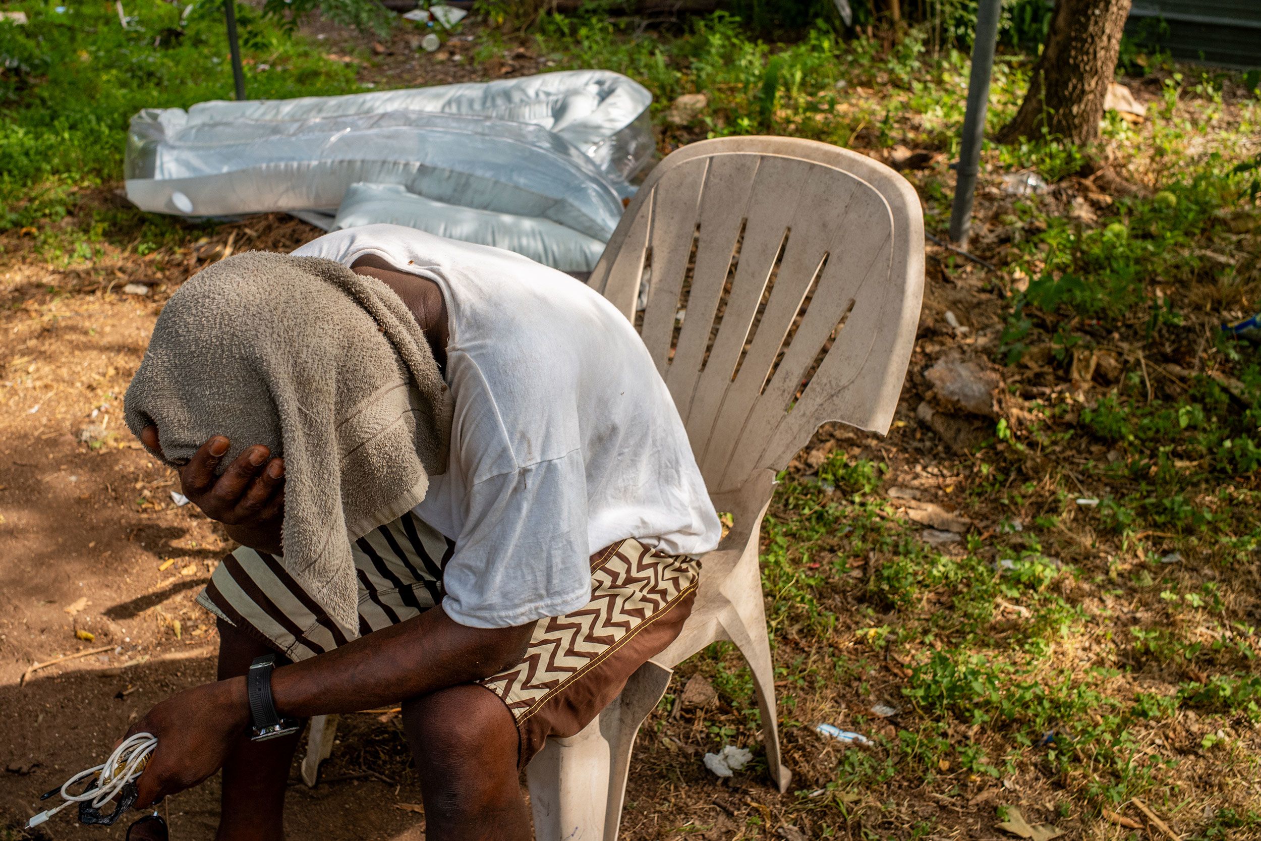 Dymond Black sits with a towel over his head in Austin, Texas, on June 19.