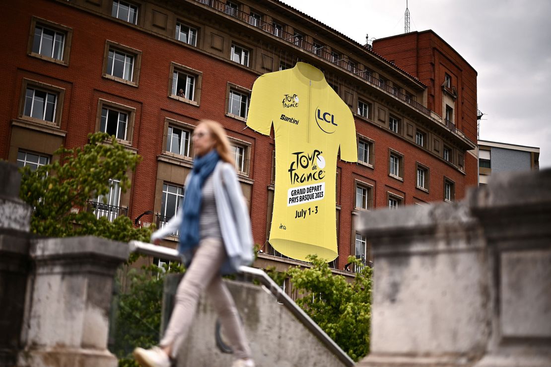 A pedestrian walks past a giant yellow jersey ahead of the 110th edition of the Tour de France cycling race, in Bilbao, on July 27, 2023. The Tour de France will start in Bilbao, on July 1, 2023. (Photo by Marco BERTORELLO / AFP) (Photo by MARCO BERTORELLO/AFP via Getty Images)