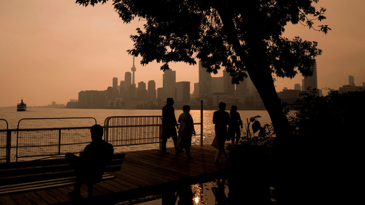 People watch the sunset as the smoke from wildfires drifts into Toronto on Wednesday.