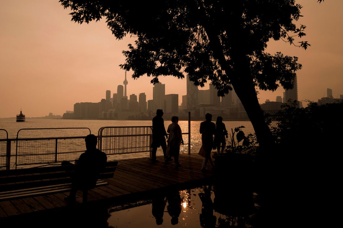 People watch the sunset as the smoke from wildfires drifts into Toronto on Wednesday.