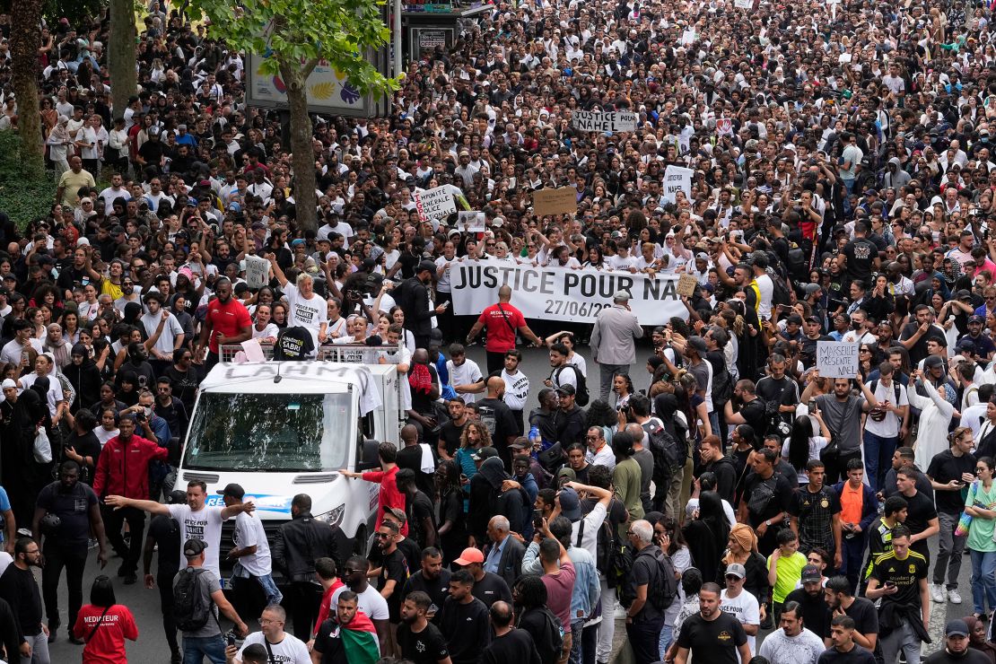 The mother of 17-year-old Nahel, seen at left on a truck, gestures during a march on Thursday.