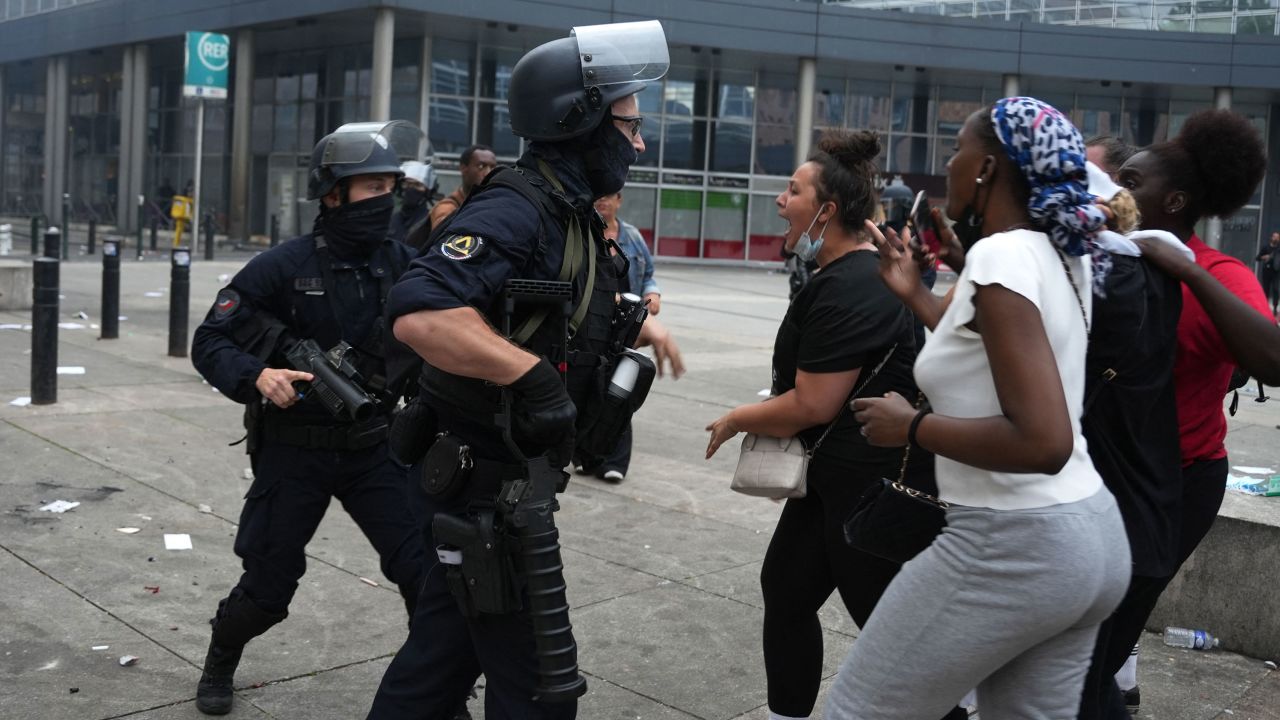 Полицейские сталкиваются с протестующими во время столкновений, вспыхнувших в парижском пригороде Нантер 29 июня.
