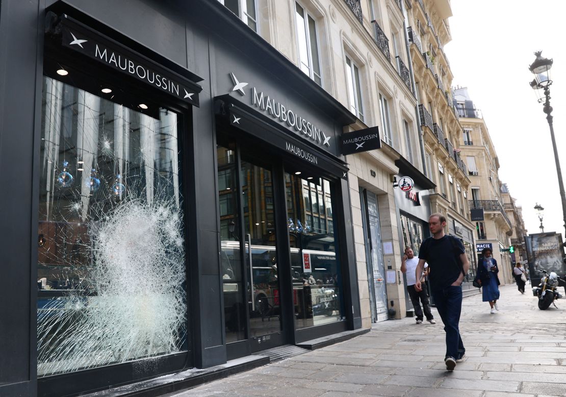 A man walks past the damaged window of a Mauboussin store vandalised during a night of clashes between protesters and police following the death of Nahel, a 17-year-old teenager killed by a French police officer in Nanterre during a traffic stop, at Rue de Rivoli in Paris, France, June 30, 2023. REUTERS/Yves Herman