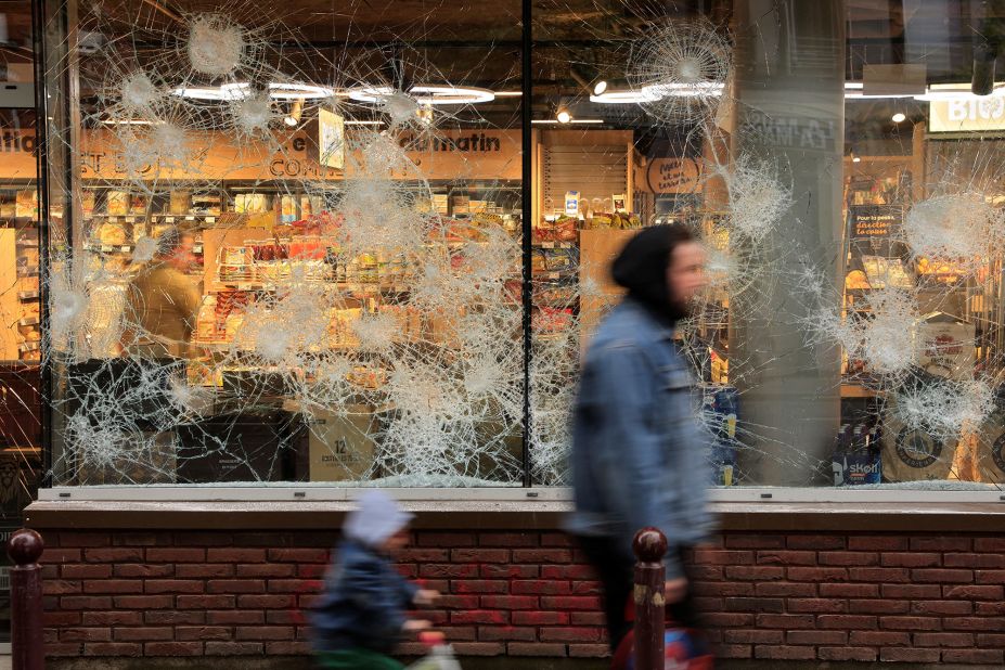 People walk past a vandalized shop in Lille on June 30.