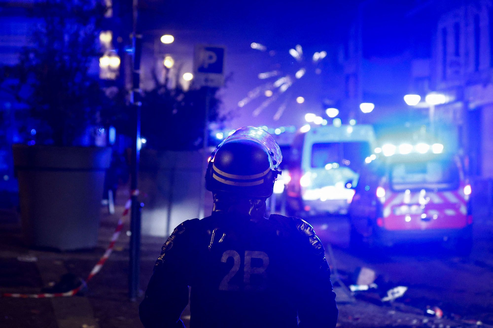 Fireworks explode as policemen stand by during protests in Roubaix on June 30.