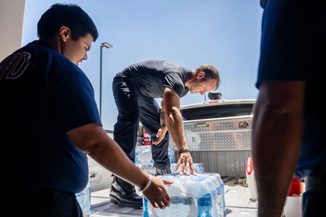 Emergency medical technicians help the Eagle Pass Fire Department stock water and ice in Eagle Pass, Texas, on Thursday, June 29.