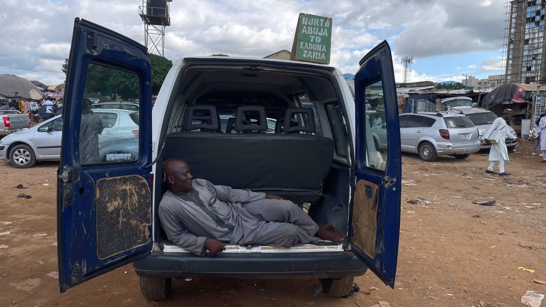 Jume Hanwa takes a nap at the trunk of his empty vehicle at Utako Motor Park, an interstate bus terminal in the Nigerian capital of Abuja.