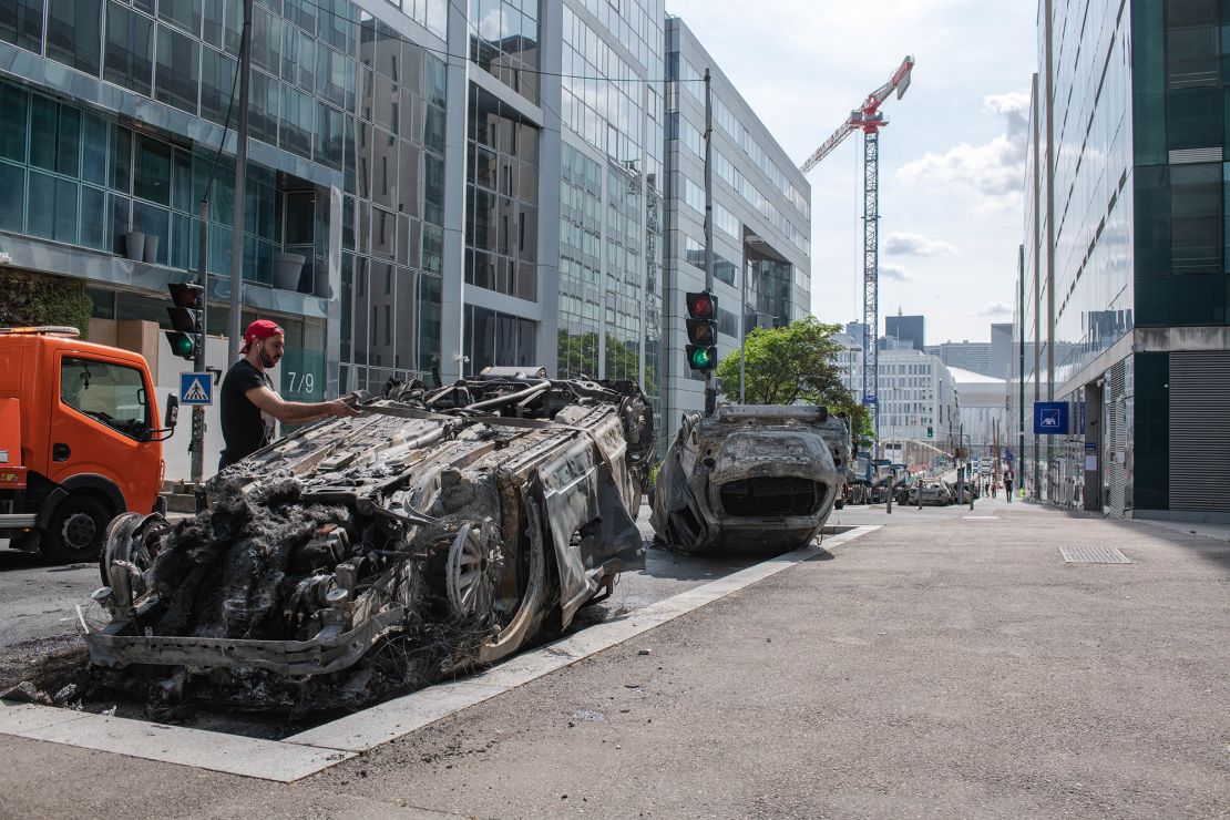 Workers clear a street filled with charred cars in Nanterre, France, on Friday.