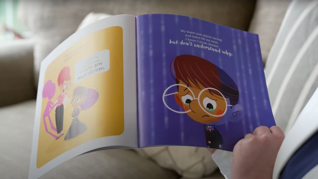 Teacher Katie Rinderle flips through "My Shadow is Purple."
