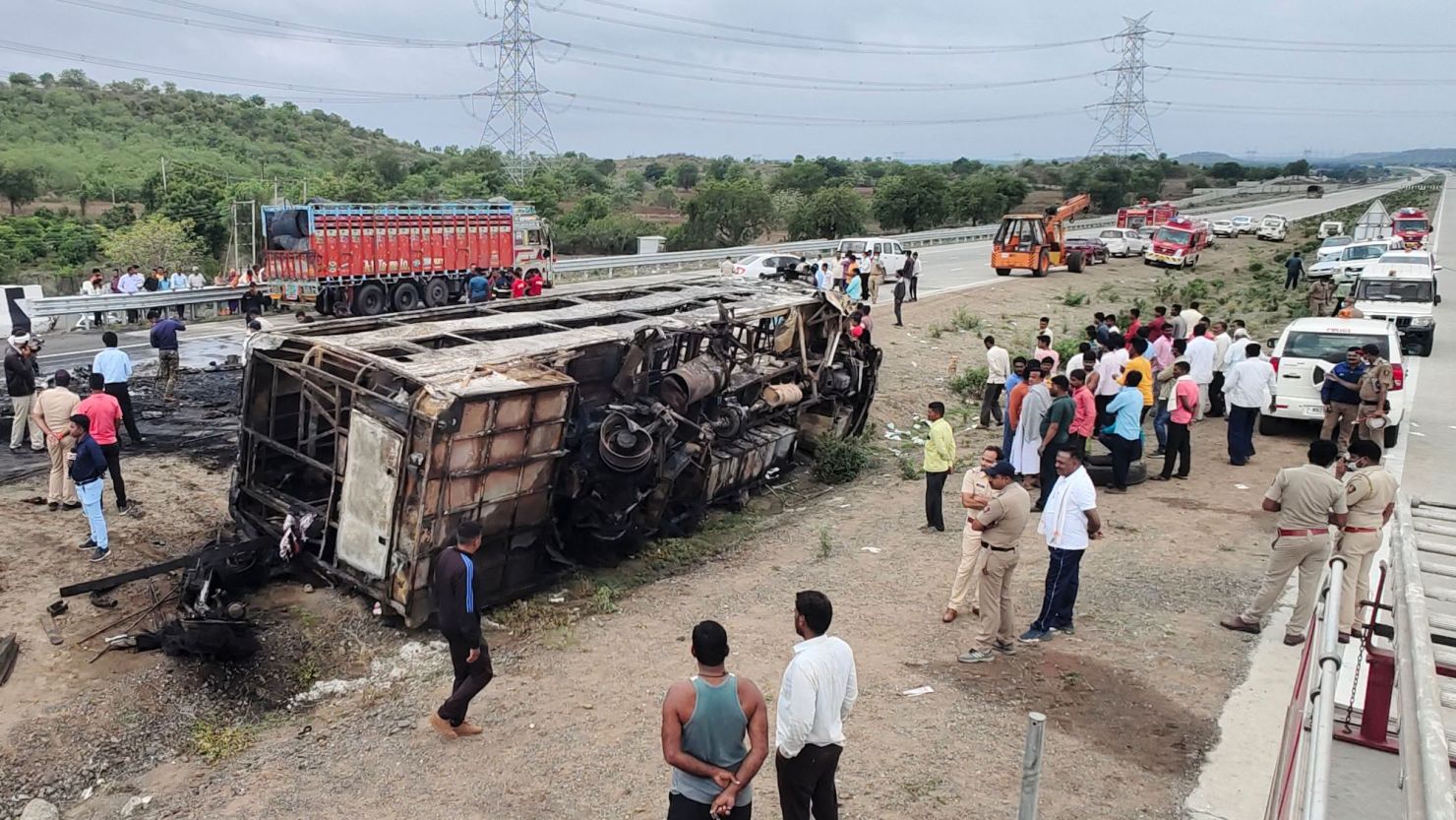 People gather around the wreckage of a bus that caught fire along the Samruddhi Mahamarg expressway near Sindkhed Raja in the Buldhana district of Maharashtra state, India, on July 1, 2023.