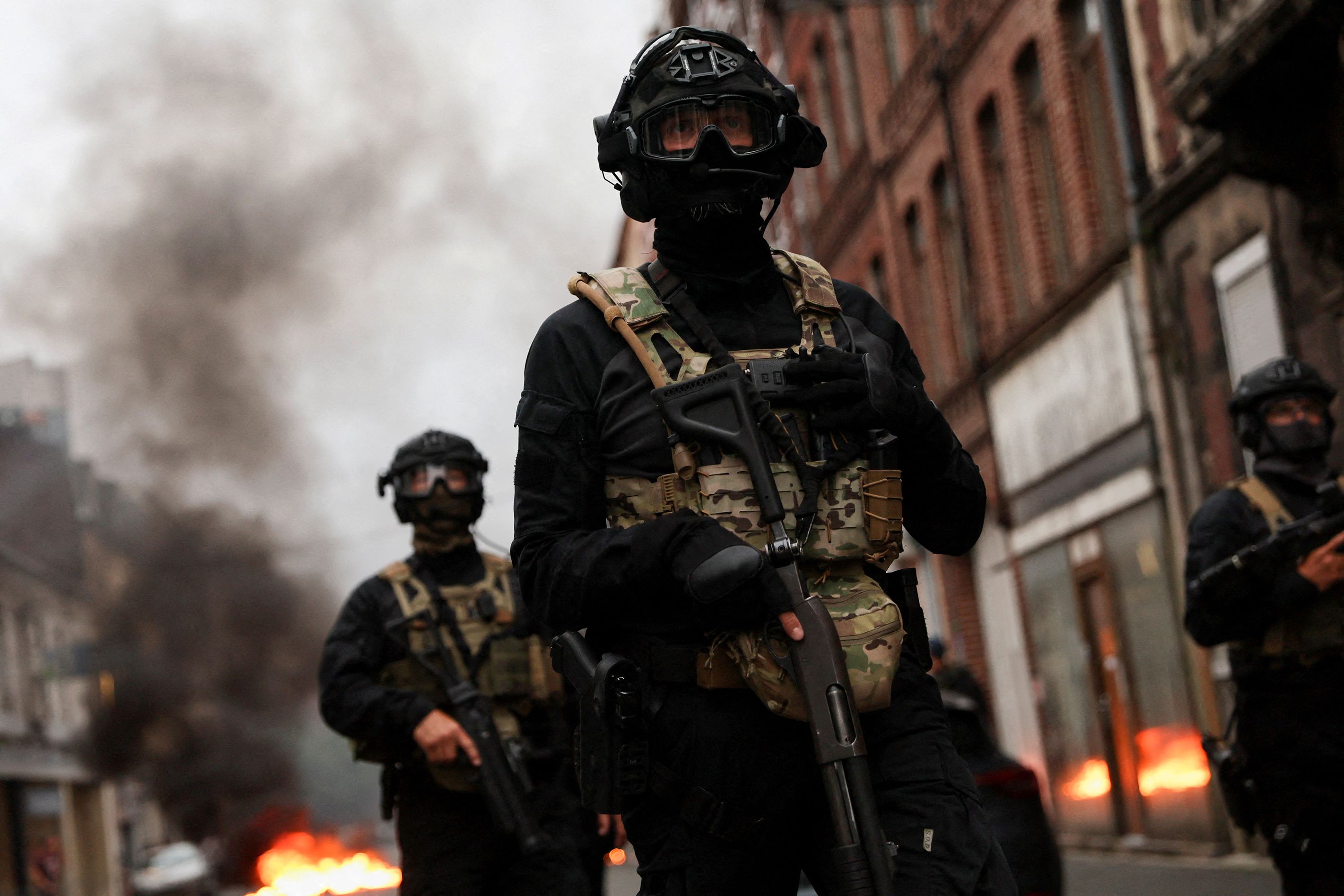 Officers stand guard during riots in Lille, France, on June 30.