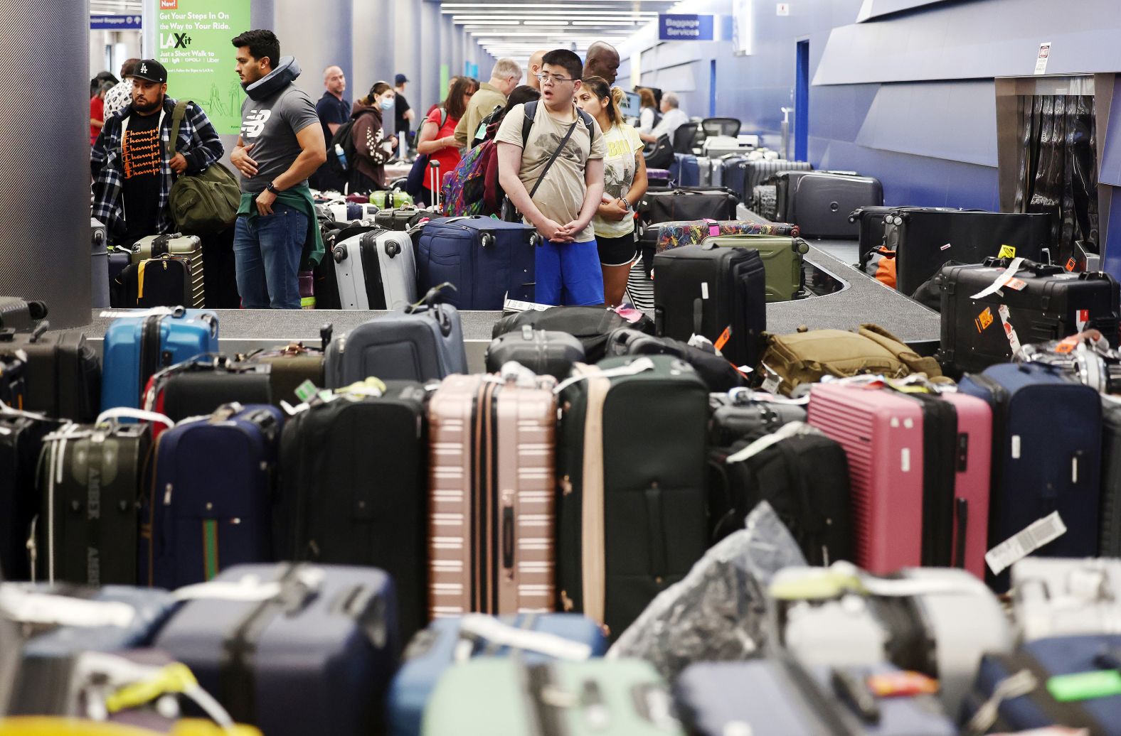 Travelers wait for their bags Thursday amid rows of luggage at Los Angeles International Airport.