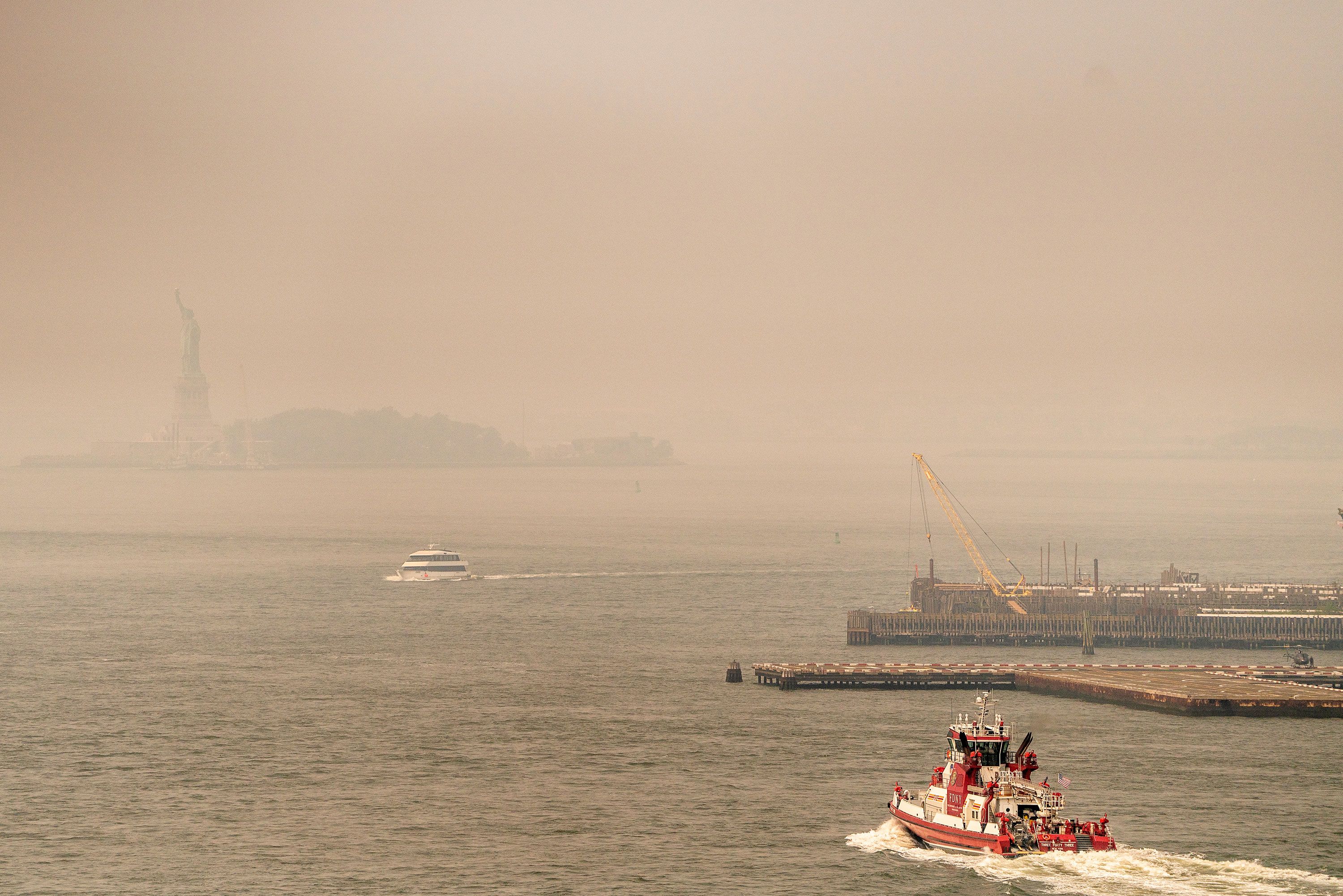 Smoke from wildfires in Canada shrouds the view of the Statue of Liberty on Friday in New York.