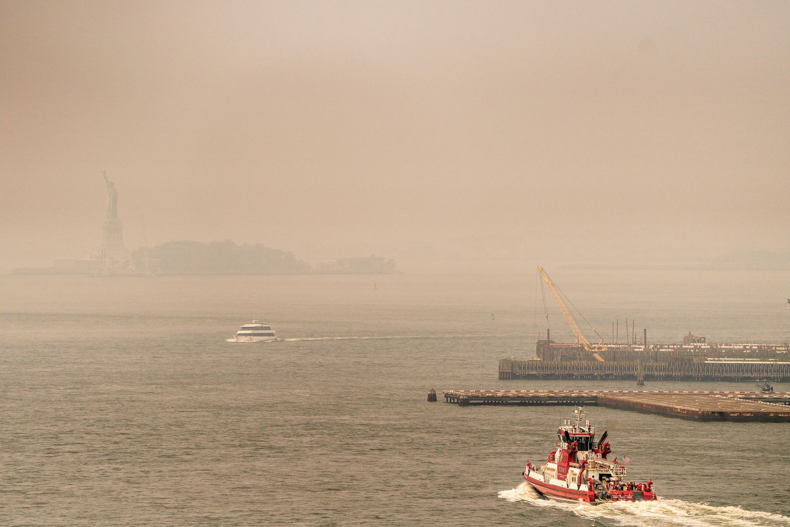 Smoke from wildfires in Canada shrouds the view of the Statue of Liberty on Friday in New York.