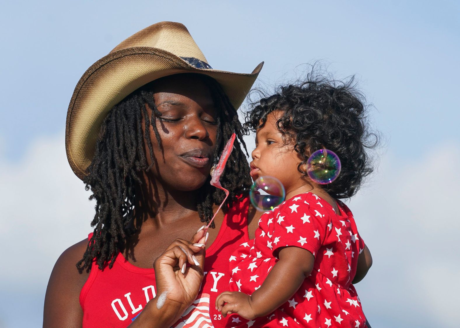 Janay Tate blows bubbles with her daughter Imory during an Independence Day celebration in Indiantown, Florida, on Saturday.