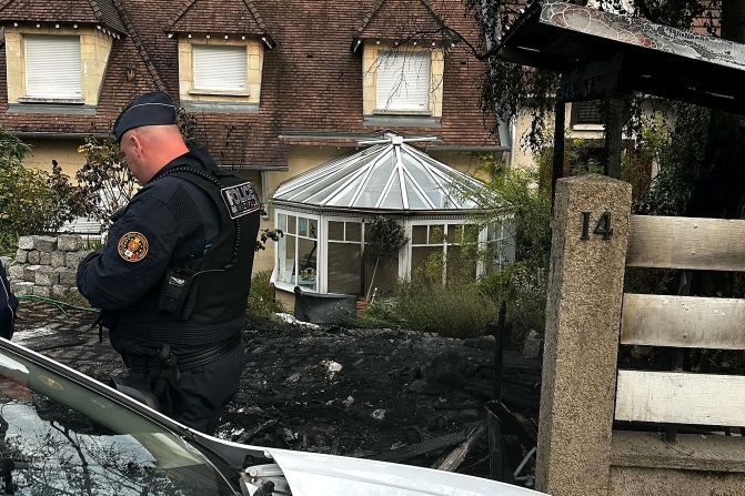 A police officer stands in front of the damaged home of Vincent Jeanbrun, the mayor of L'Haÿ-les-Roses, after <a href="index.php?page=&url=https%3A%2F%2Fedition.cnn.com%2F2023%2F07%2F02%2Fworld%2Ffrance-protests-violence-mayors-house-attack-intl-hnk%2Findex.html" target="_blank">rioters rammed a vehicle</a> into the building overnight on Sunday, July 2. Jeanbrun said his wife and one of his children were injured. 
