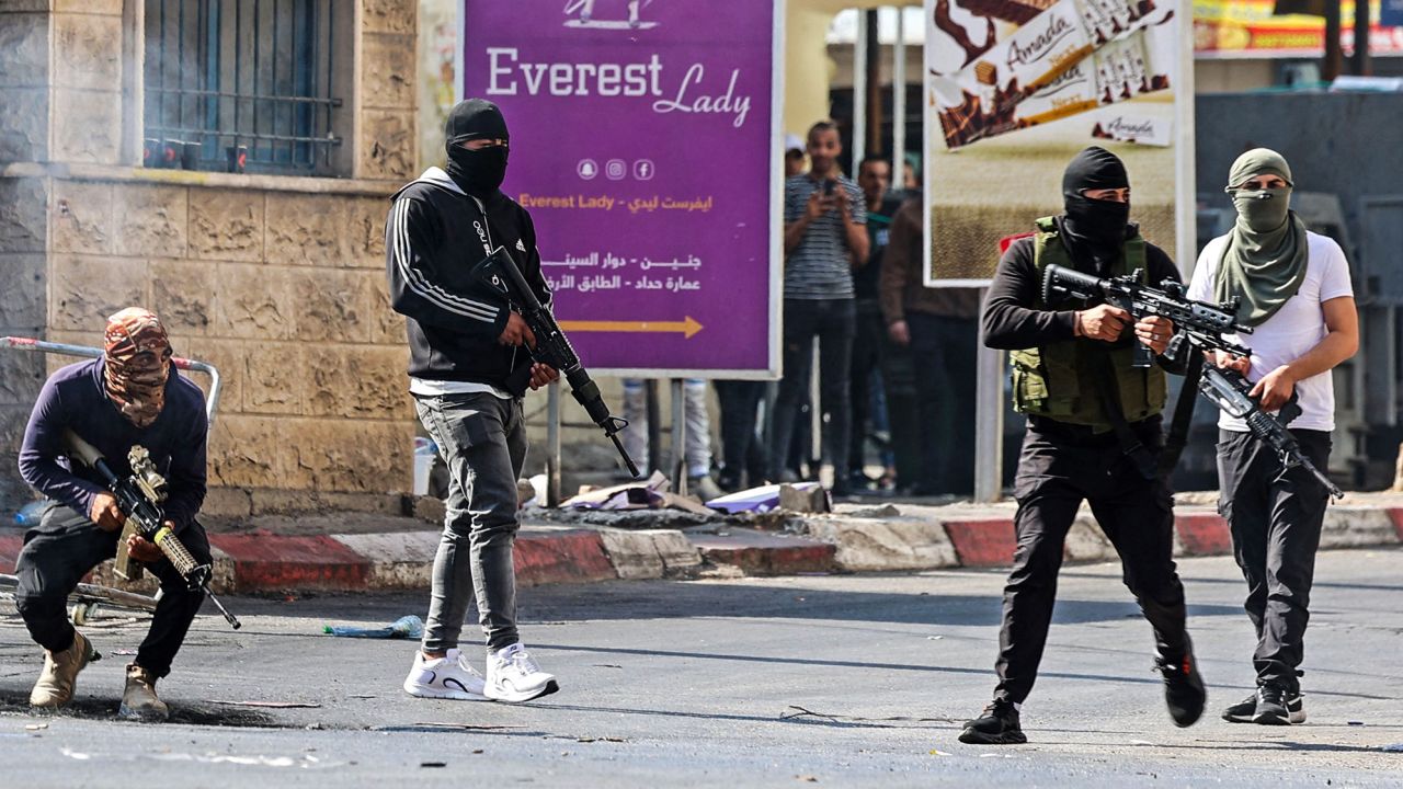 Palestinian armed militants take up positions during a clash with Israeli forces in Jenin on Monday.