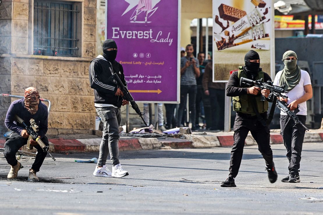 Palestinian armed militants take up positions during a clash with Israeli forces in Jenin on Monday.