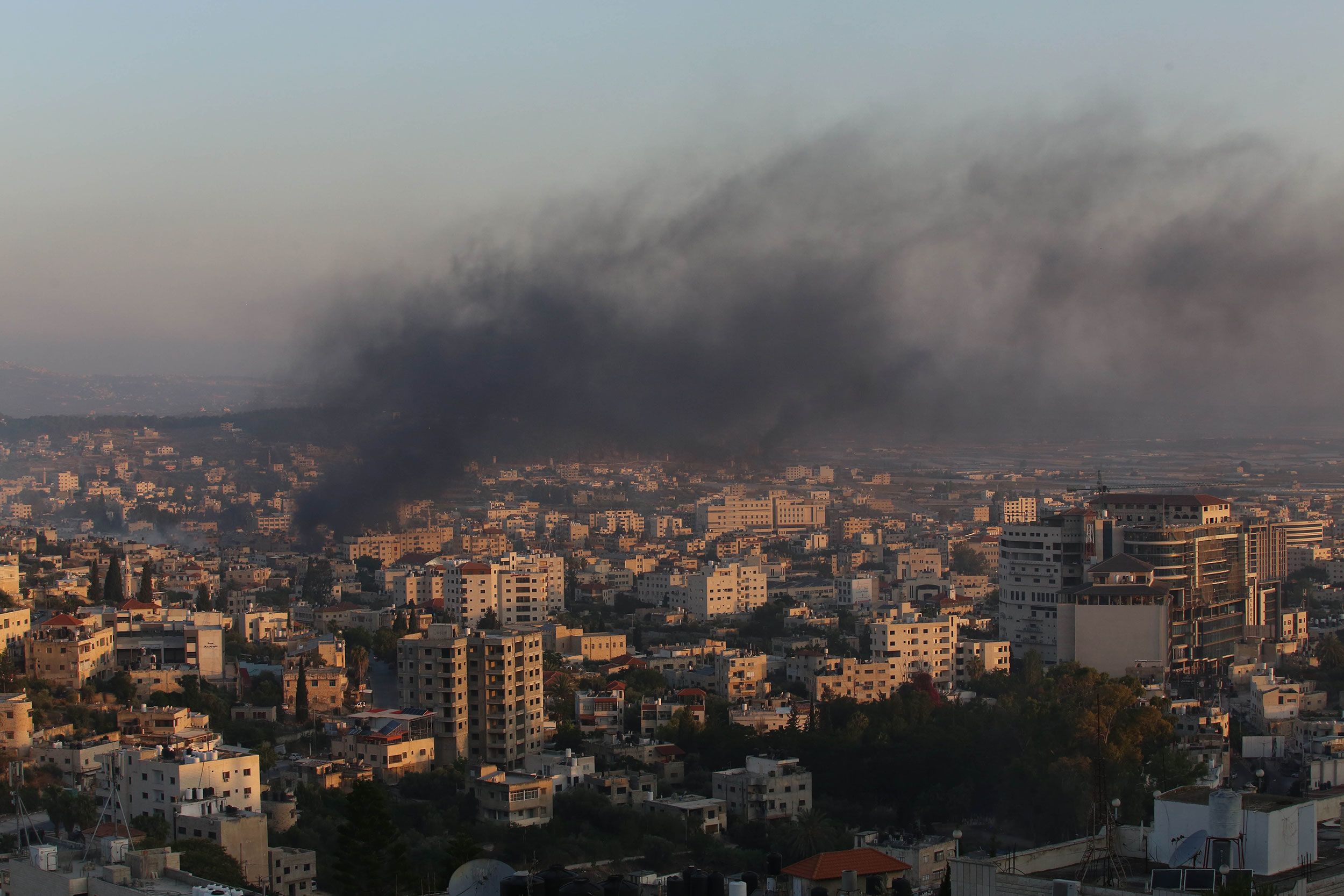 Smoke rises from buildings in Jenin on Monday.