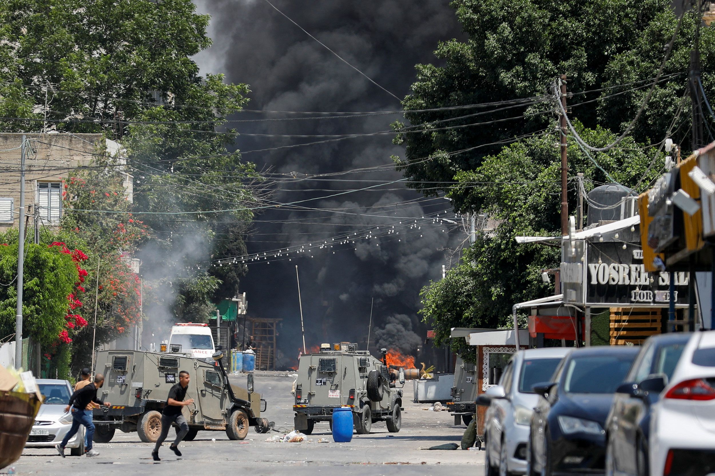 Palestinians run for cover during the Israeli military operation in Jenin.