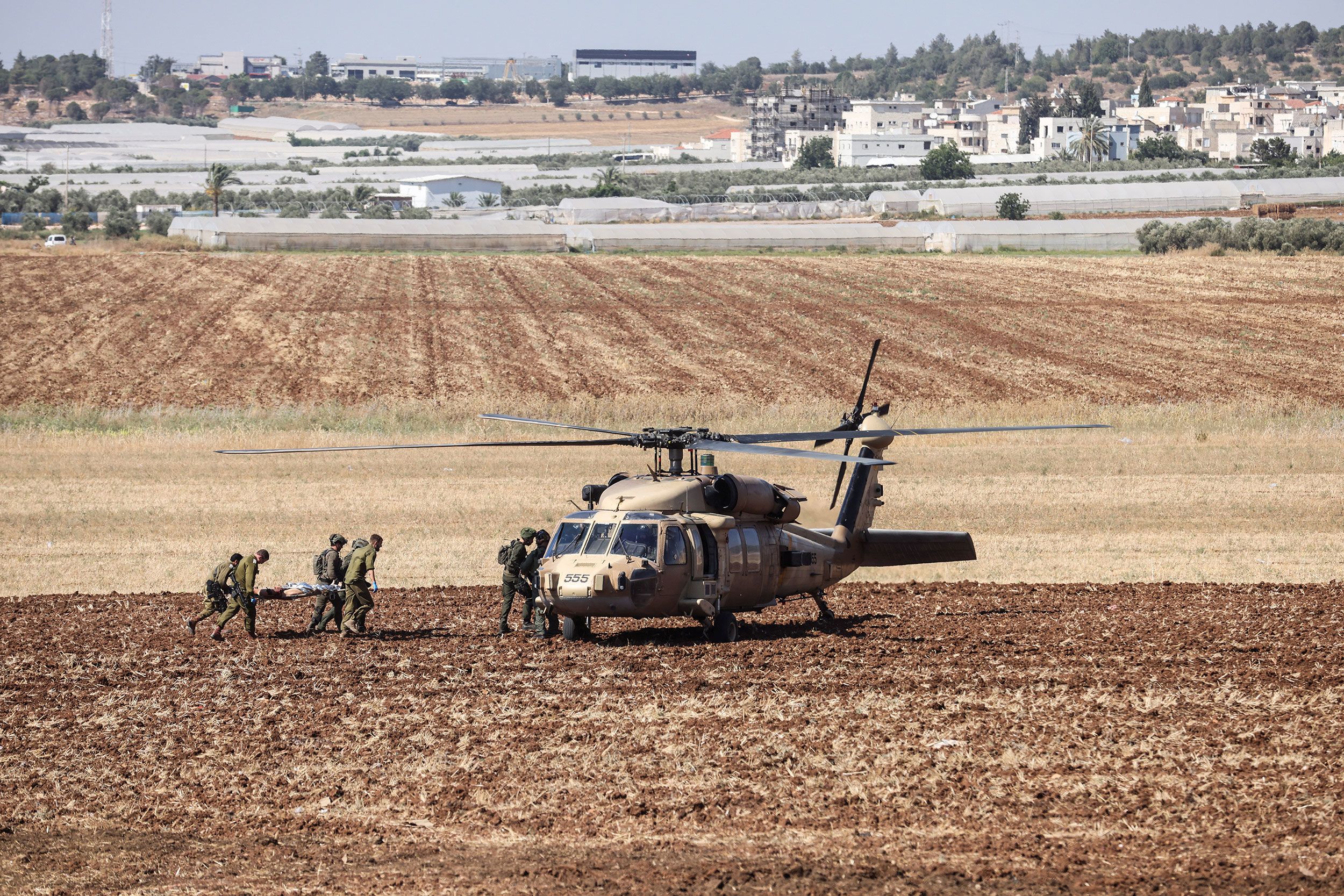 Israeli military carry a wounded person to a helicopter on Monday.