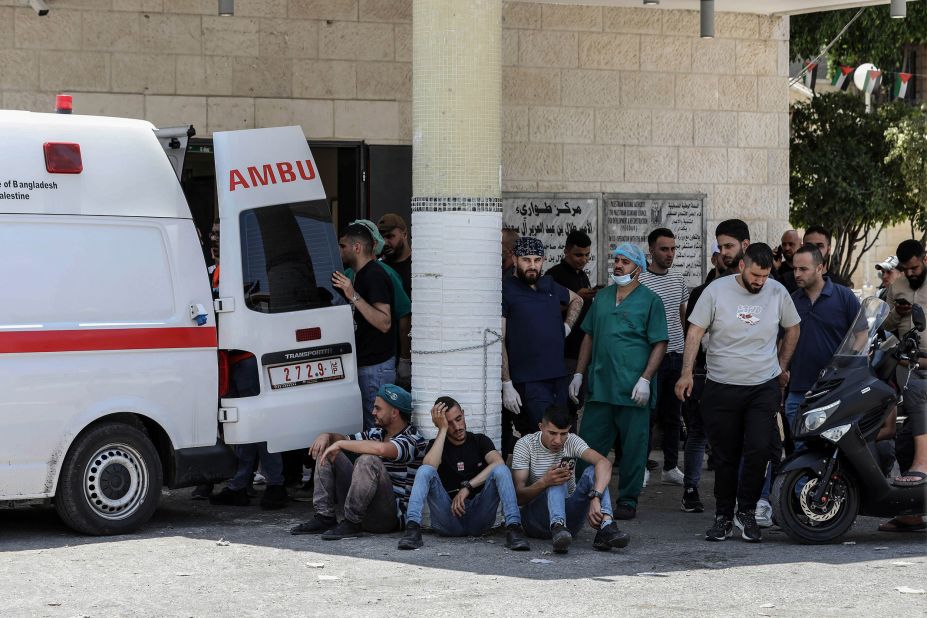 Palestinians wait outside a hospital in Jenin while paramedics transport injured people on Monday.