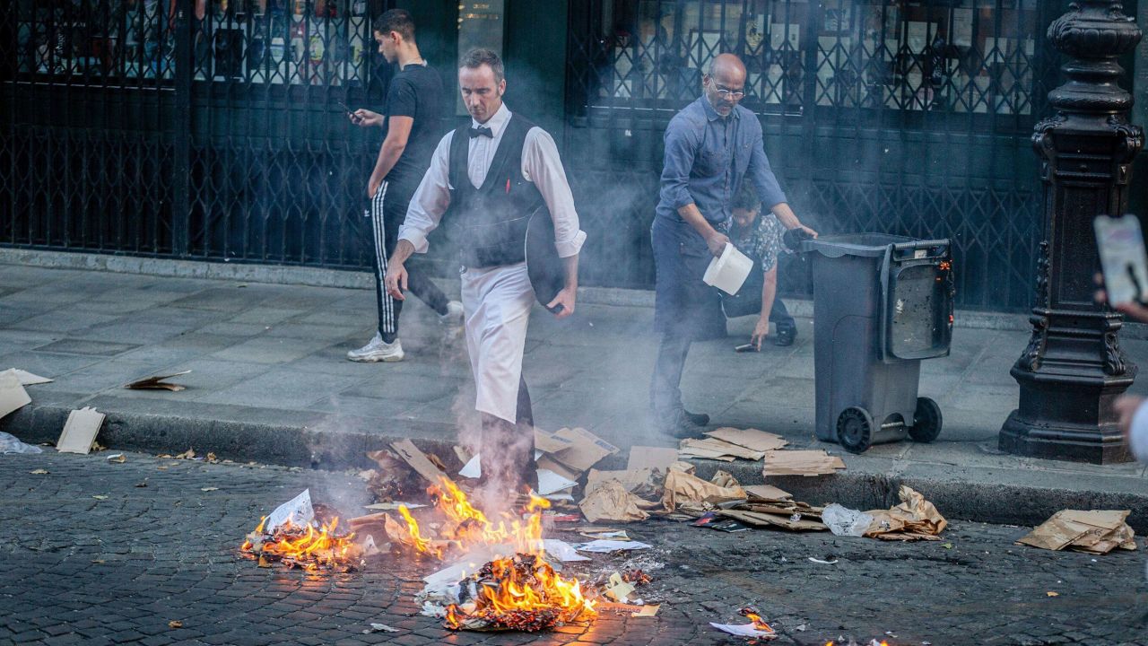 Restuarant employees try to put out a fire during a protest in Paris on June 30, 2023.