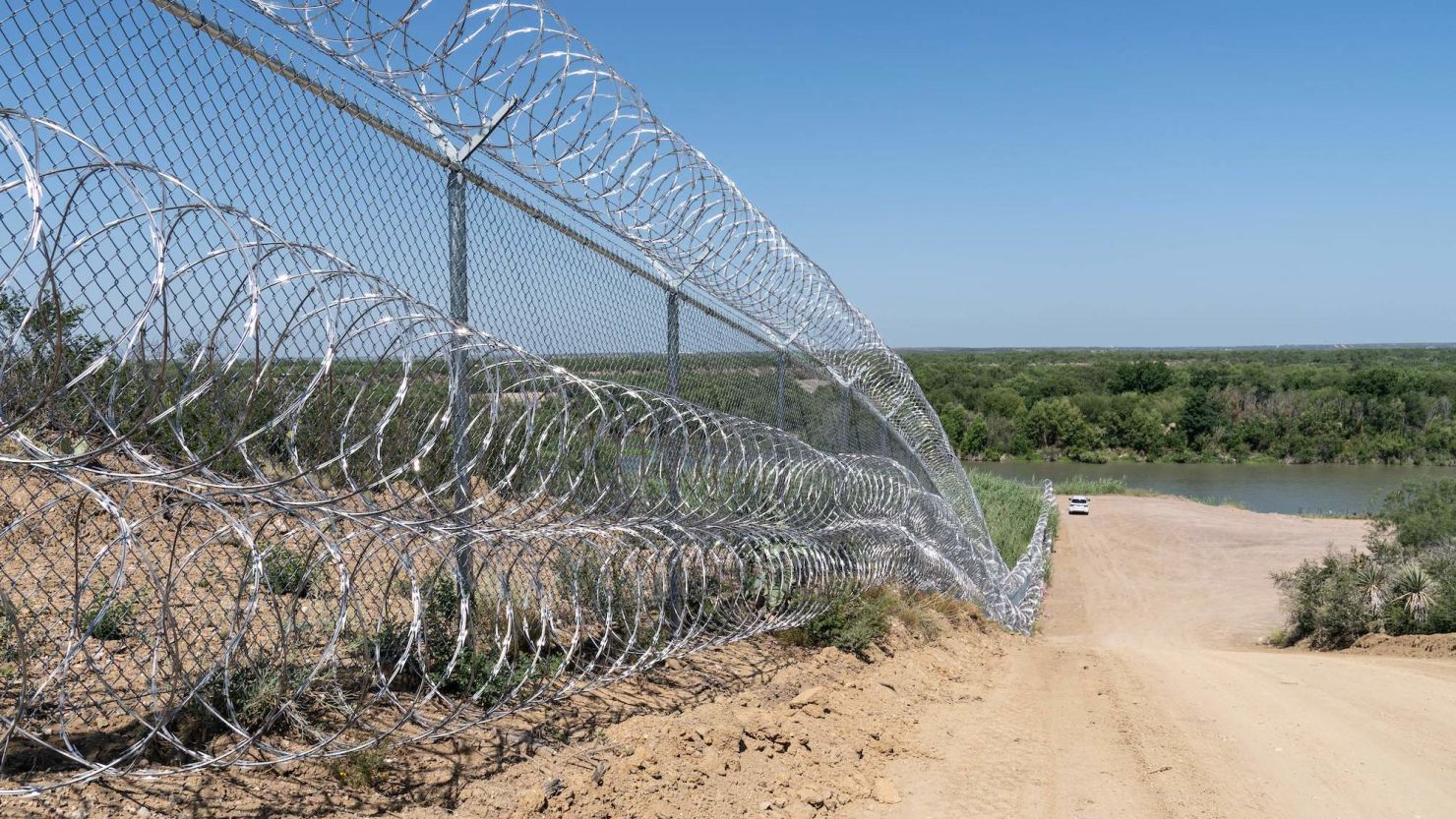 A razor wire fence runs alongside the Rio Grande River in Eagle Pass, Texas on June 16.