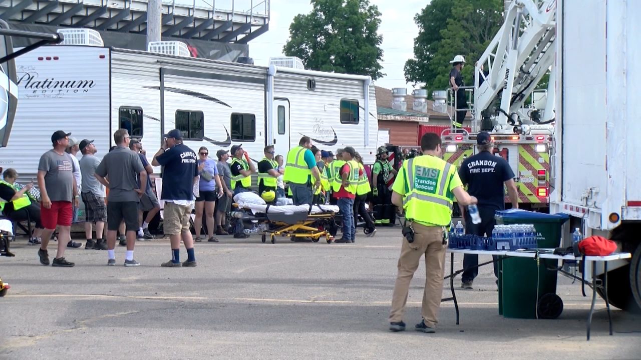 El personal de emergencia espera mientras sacan a ocho personas de una montaña rusa atascada en Crandon, Wisconsin.